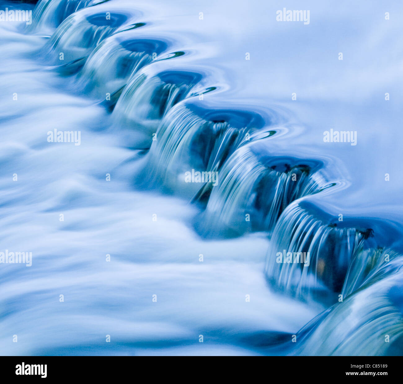 The smooth flow of water across a weir Stock Photo Alamy