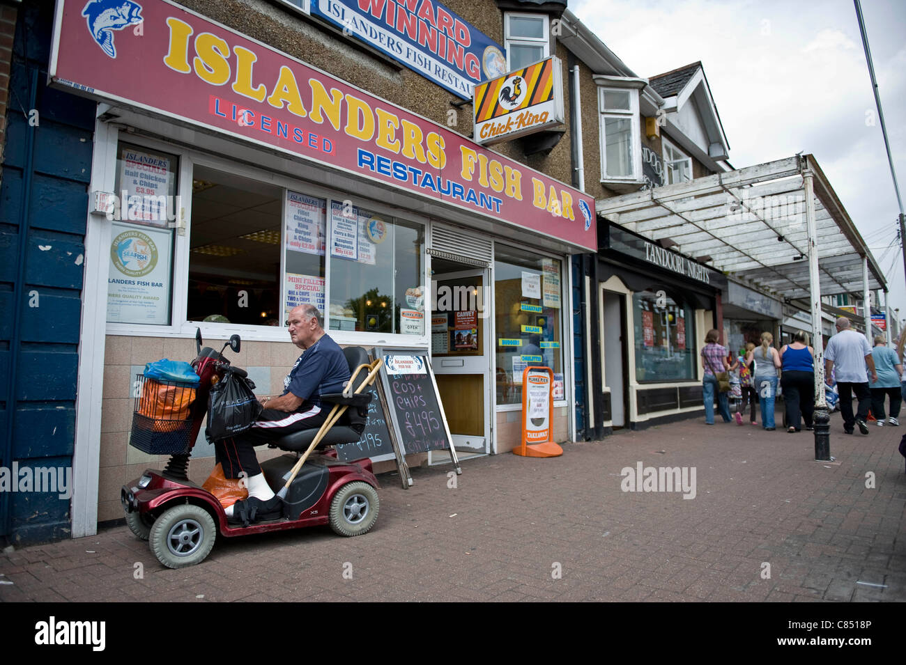 Canvey Island, Essex. Resident on a mobility scooter waiting outside a