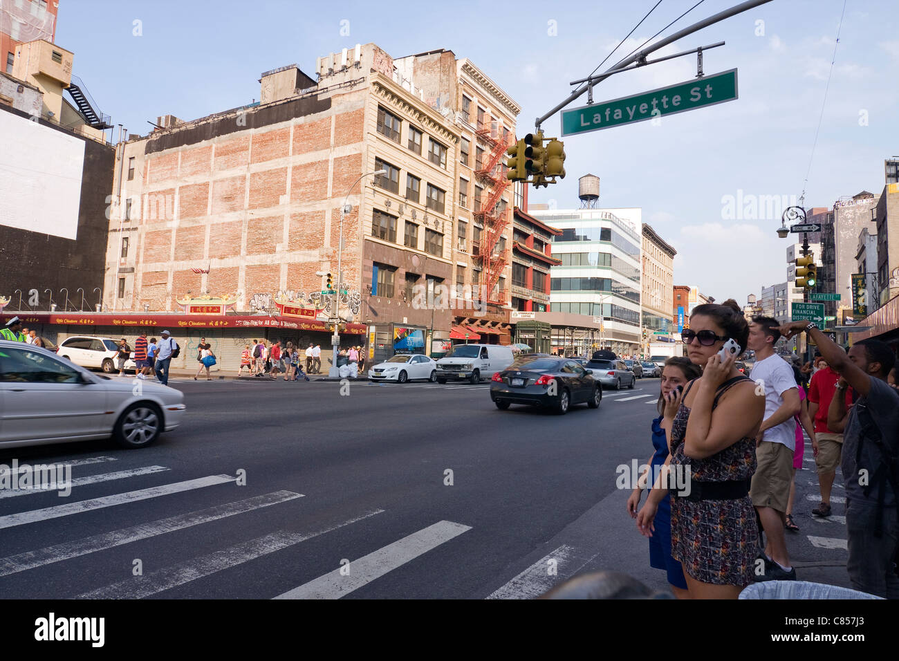 Pedestrians wait to cross the street at the intersection of Lafayette and Canal Street in New York City's Chinatown Stock Photo