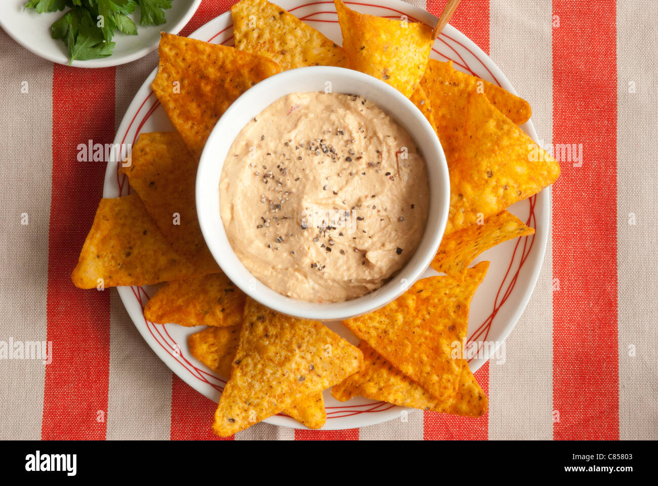 Tortilla crisps with red pepper houmous Stock Photo