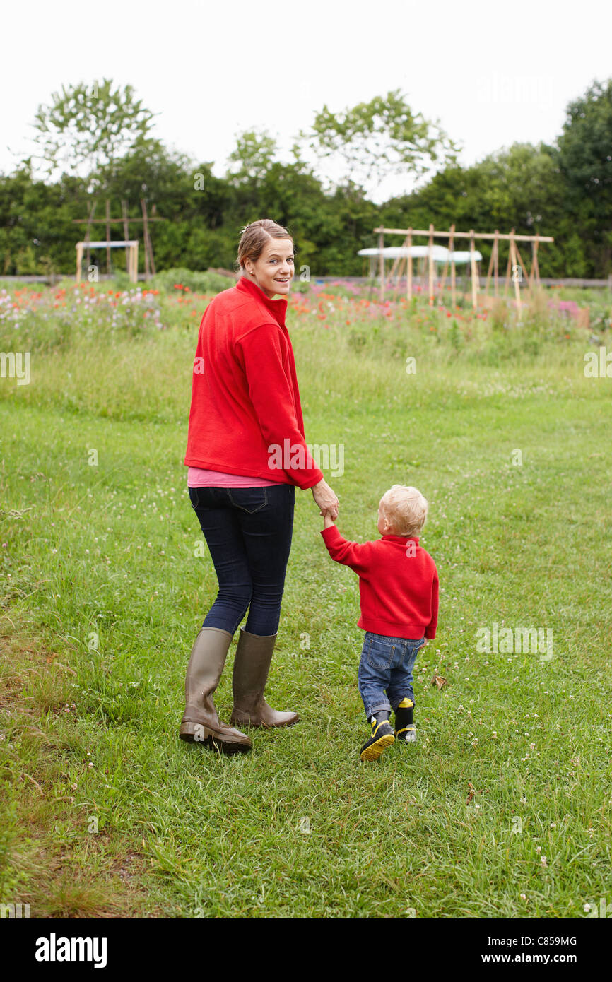Mother and son walking in field Stock Photo