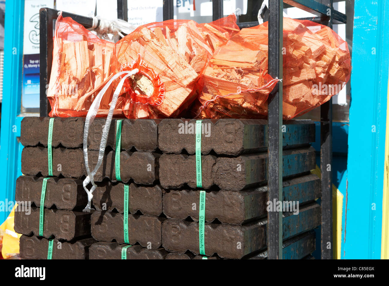 pile of bord na mona peat briquettes with sticks for sale outside a