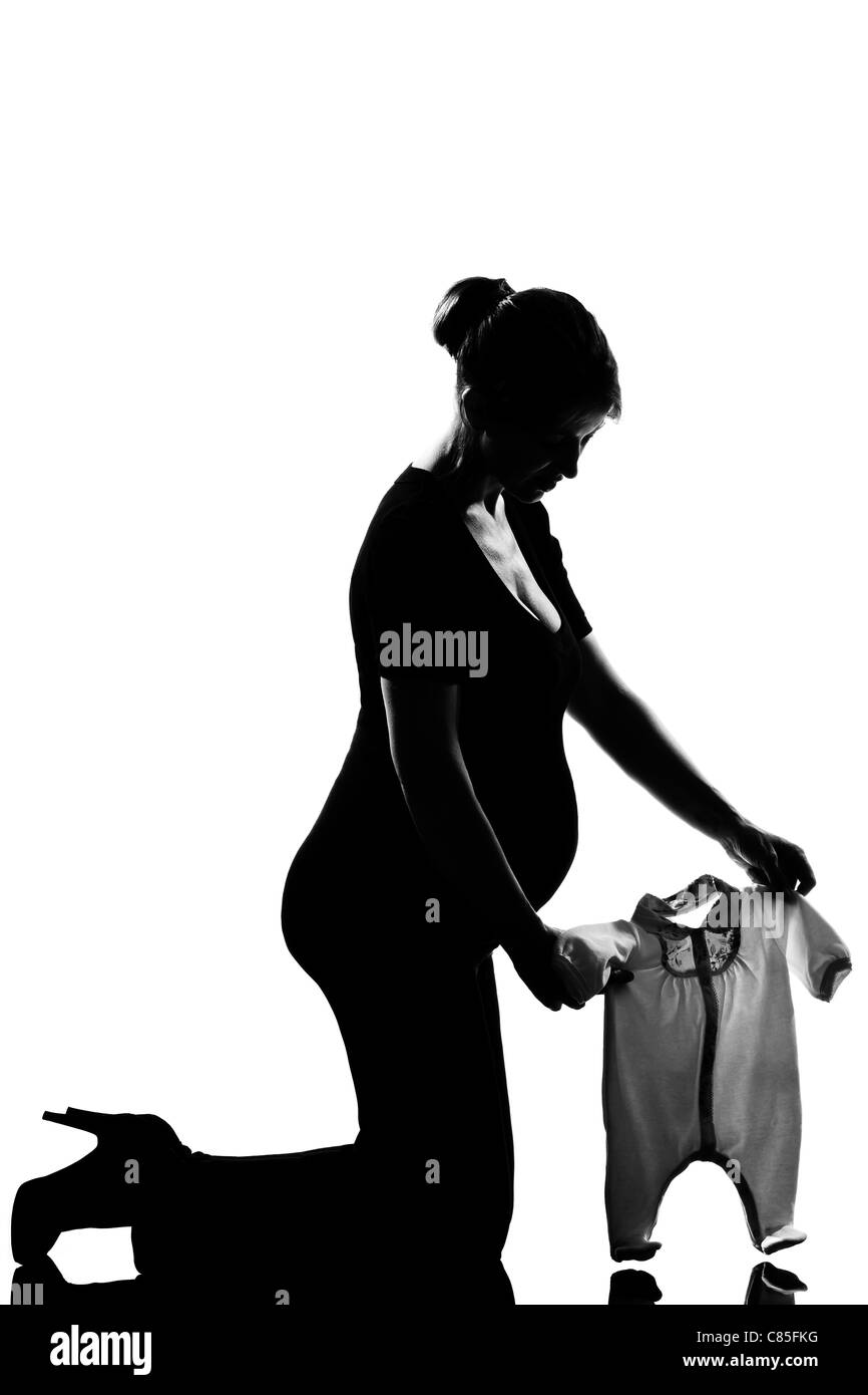 beautiful caucasian pregnant woman  baby clothes in full length silhouette on studio isolated white background Stock Photo