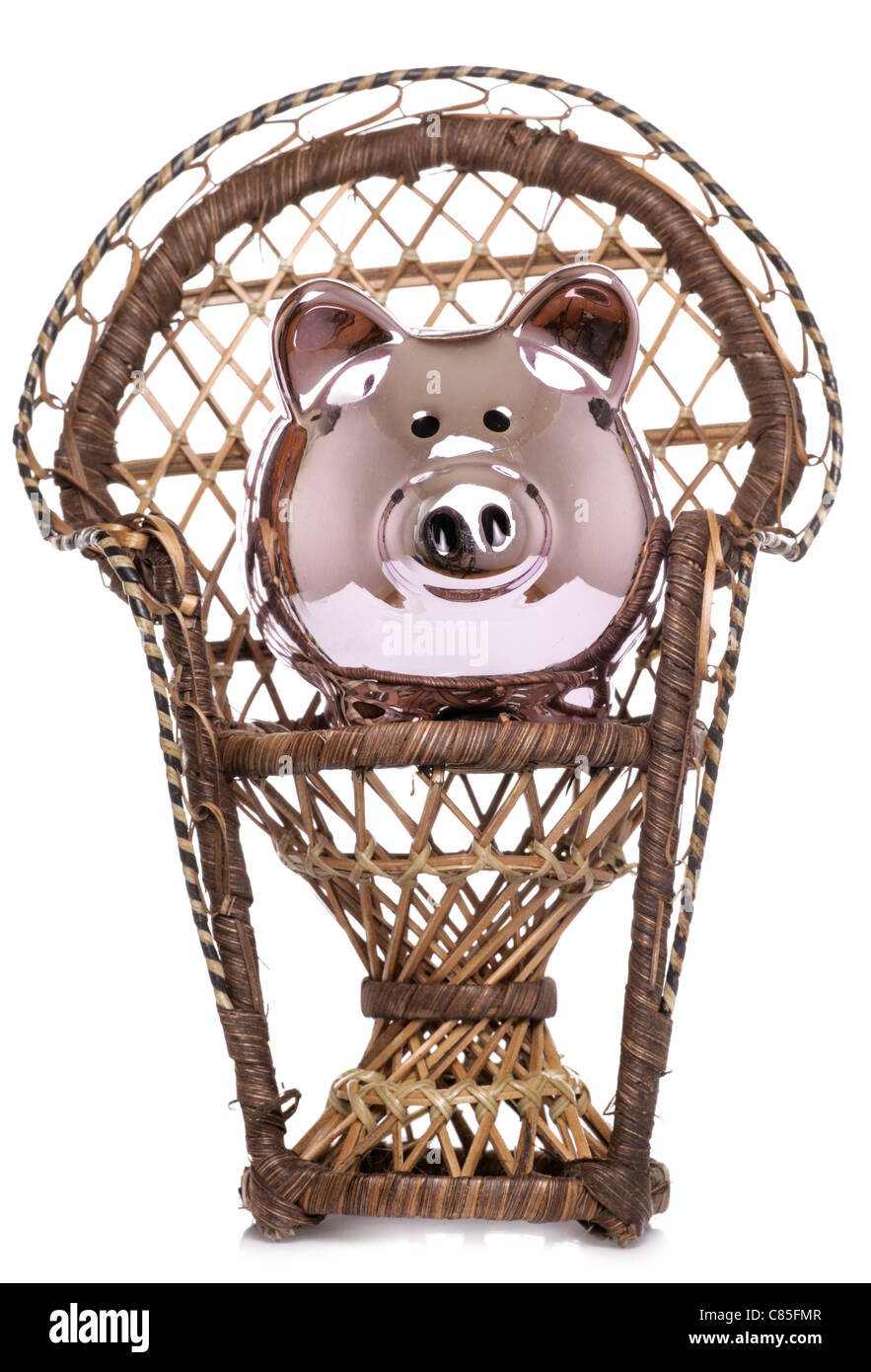 Piggybank on wicker chair studio cutout Stock Photo