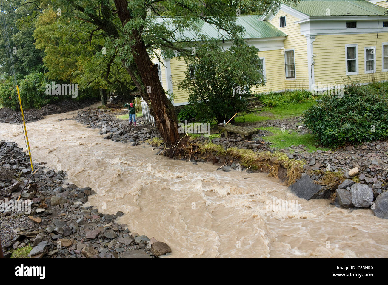 Homeowner fights floodwaters of a raging creek, September 2011, Schoharie Valley, New York State Stock Photo