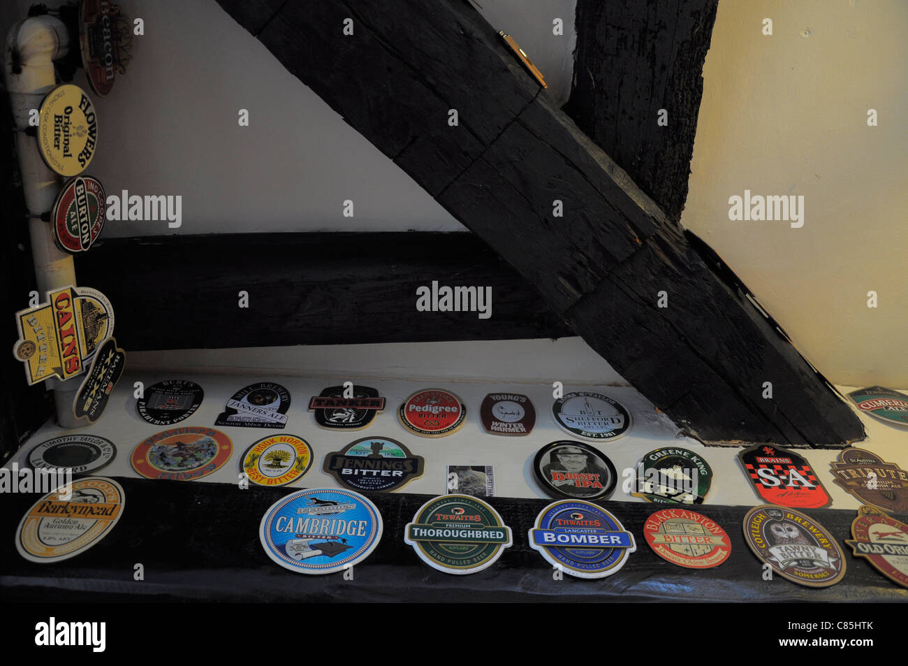 Pub interior of The Cherub Inn in Dartmouth showing traditional beer mats displayed on the wall. Stock Photo
