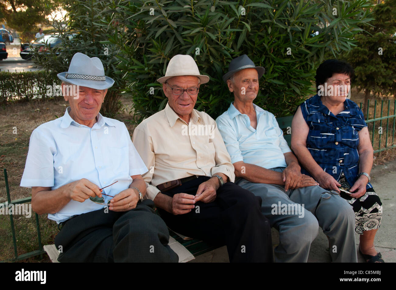 Lac. Three elderly men and one woman sit on a bench in the park Stock Photo  - Alamy