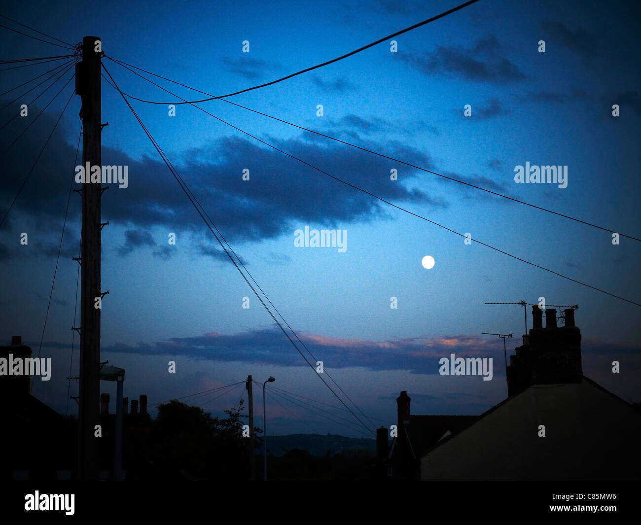 Full moon at dusk with telephone junction box in the UK Stock Photo