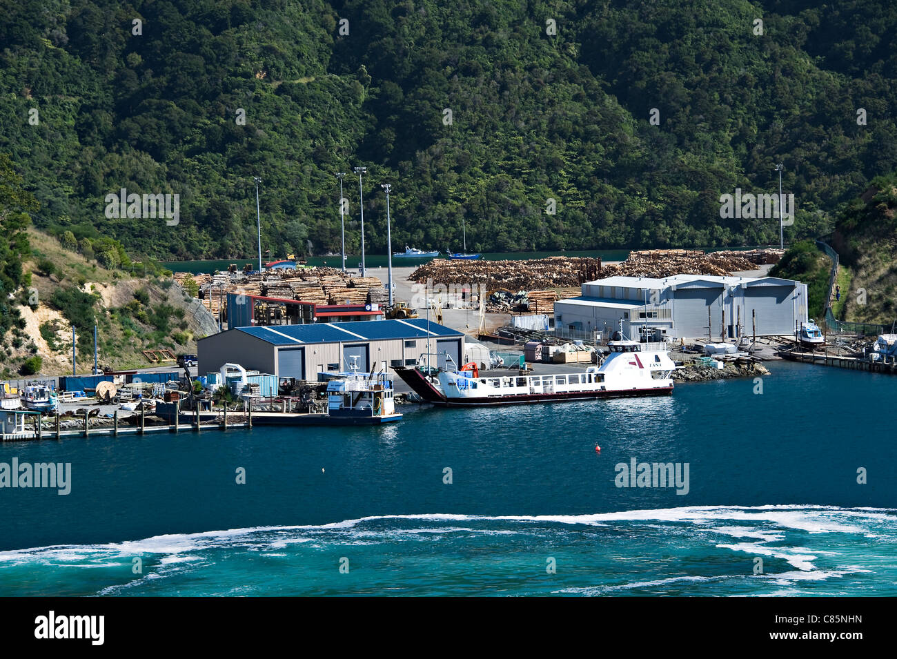 The Small Car and Passenger Ferry Lana Docked at Picton Harbour with Lumber Yard South Island New Zealand Stock Photo