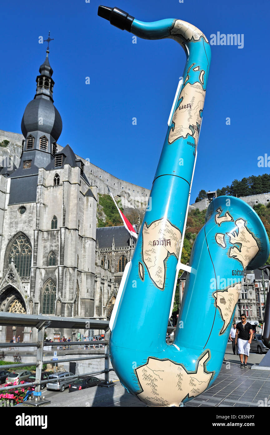 Painted saxophone and the Collegiate Church of Notre-Dame along the river Meuse at Dinant, Belgium Stock Photo