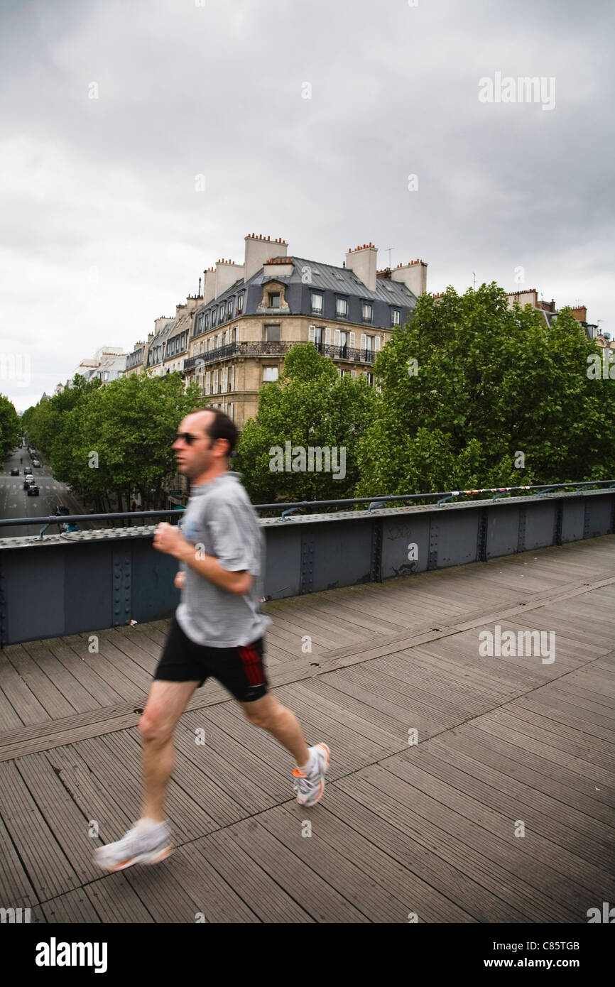 A jogger runs along the top of Le Viaduc des Arts, France Stock Photo