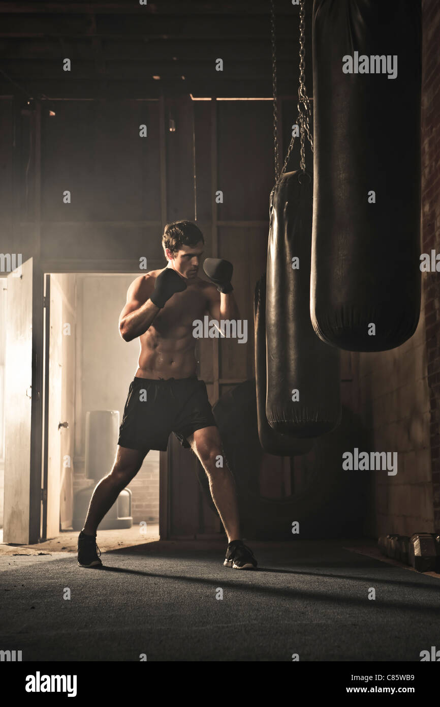Caucasian boxer hitting punching bag Stock Photo Alamy