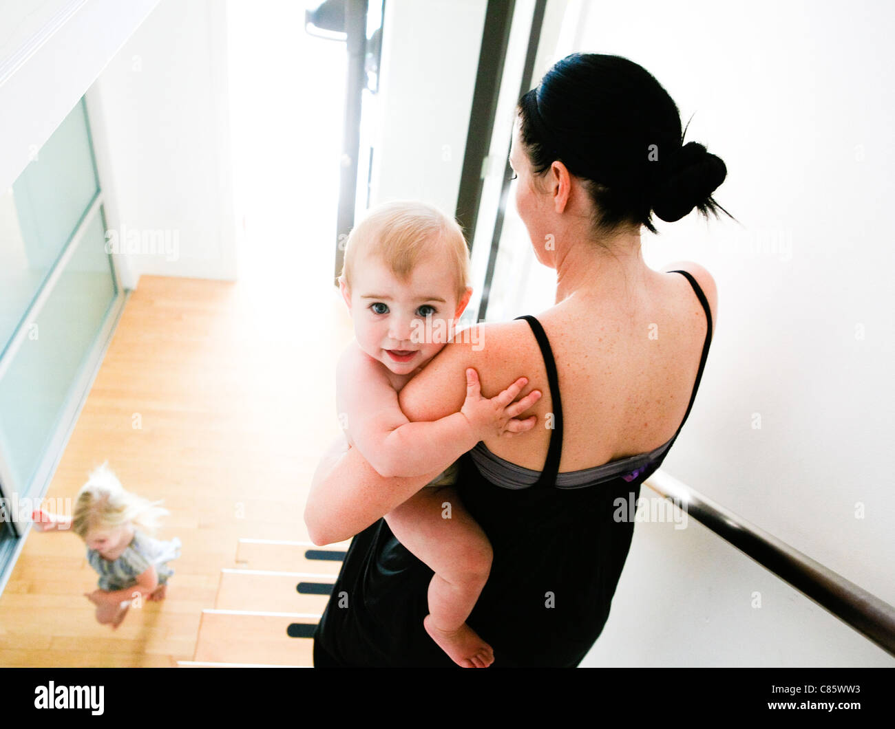 Mom carrying baby down the stairs Stock Photo Alamy