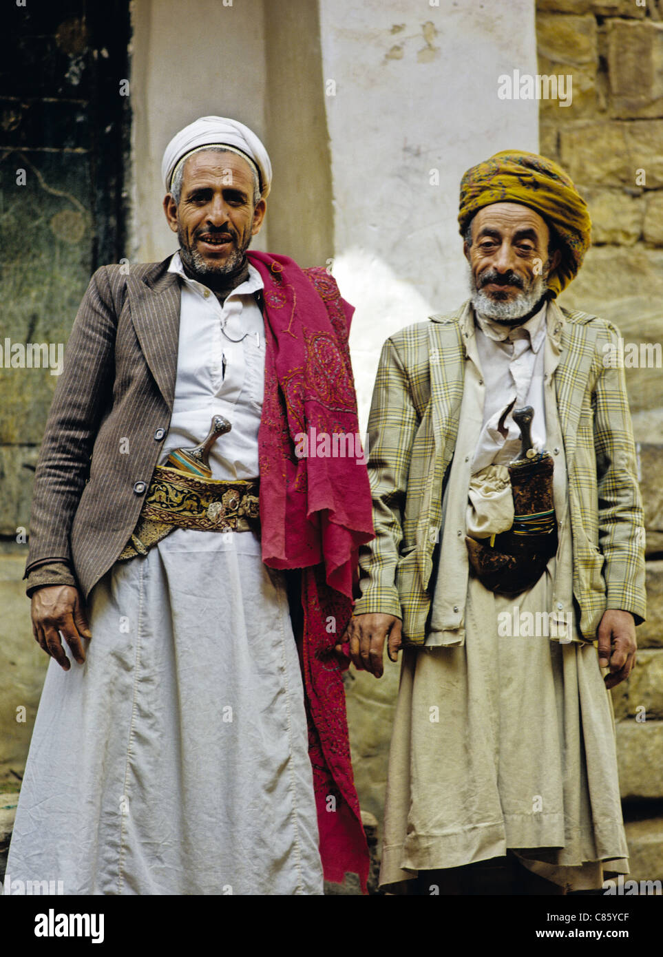Portrait of two Yemeni men wearing traditional clothing and displaying their janbiyas (traditional daggers) in Thula, Yemen Stock Photo