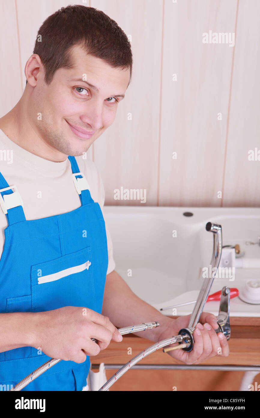 Plumber fitting a kitchen tap Stock Photo Alamy