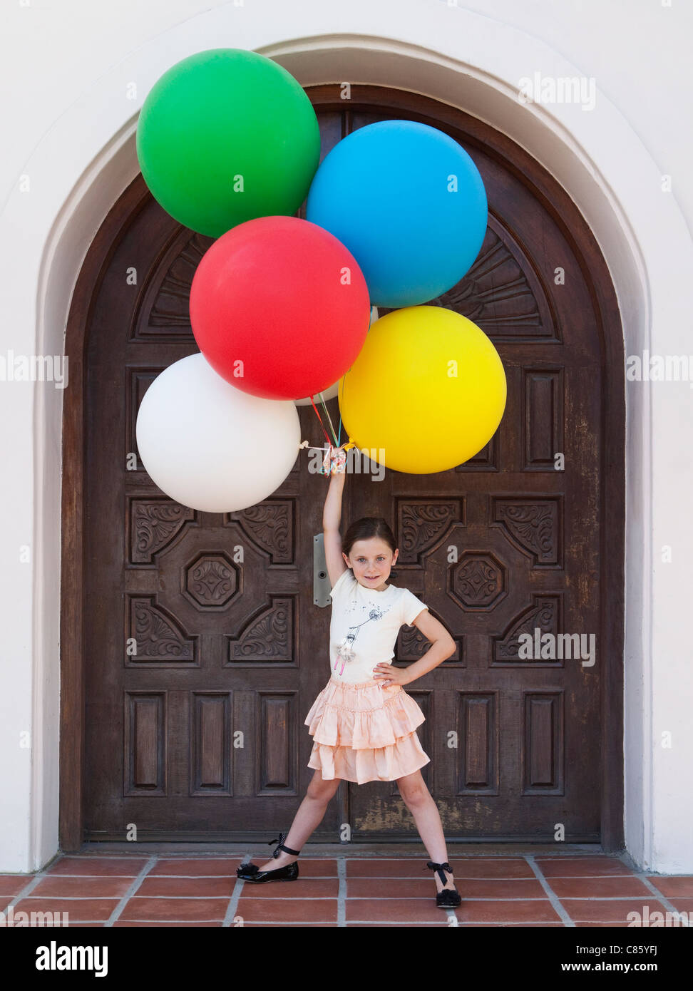 Little girl holding bunch of balloons Stock Photo