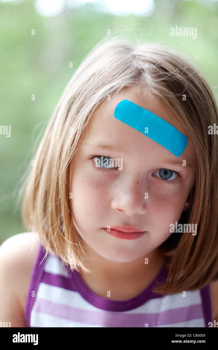 Blue bandaid on little girl's forehead Stock Photo