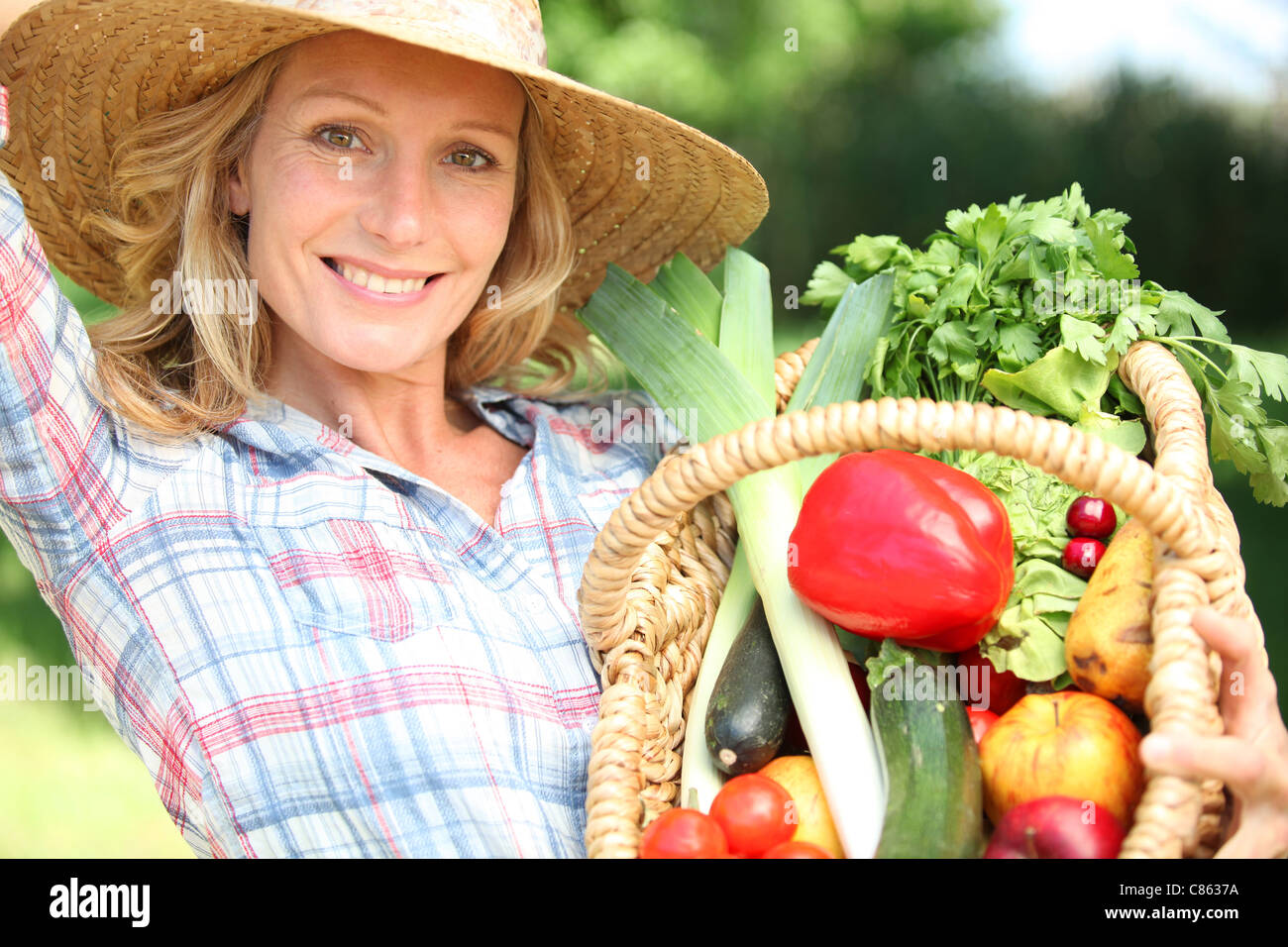 Woman with a straw hat holding basket of vegetables Stock Photo - Alamy