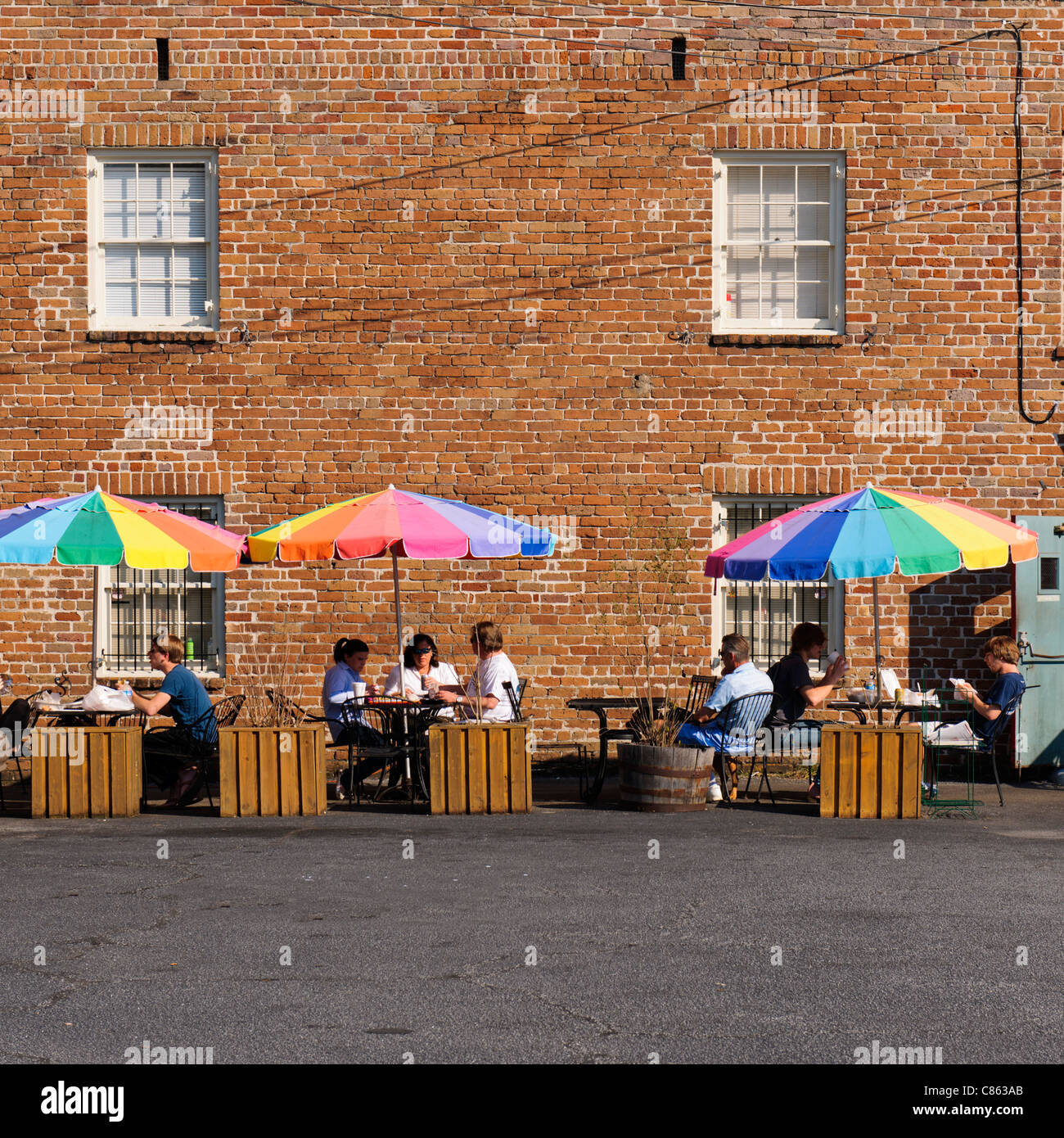 Colourful parasols against brick wall Stock Photo
