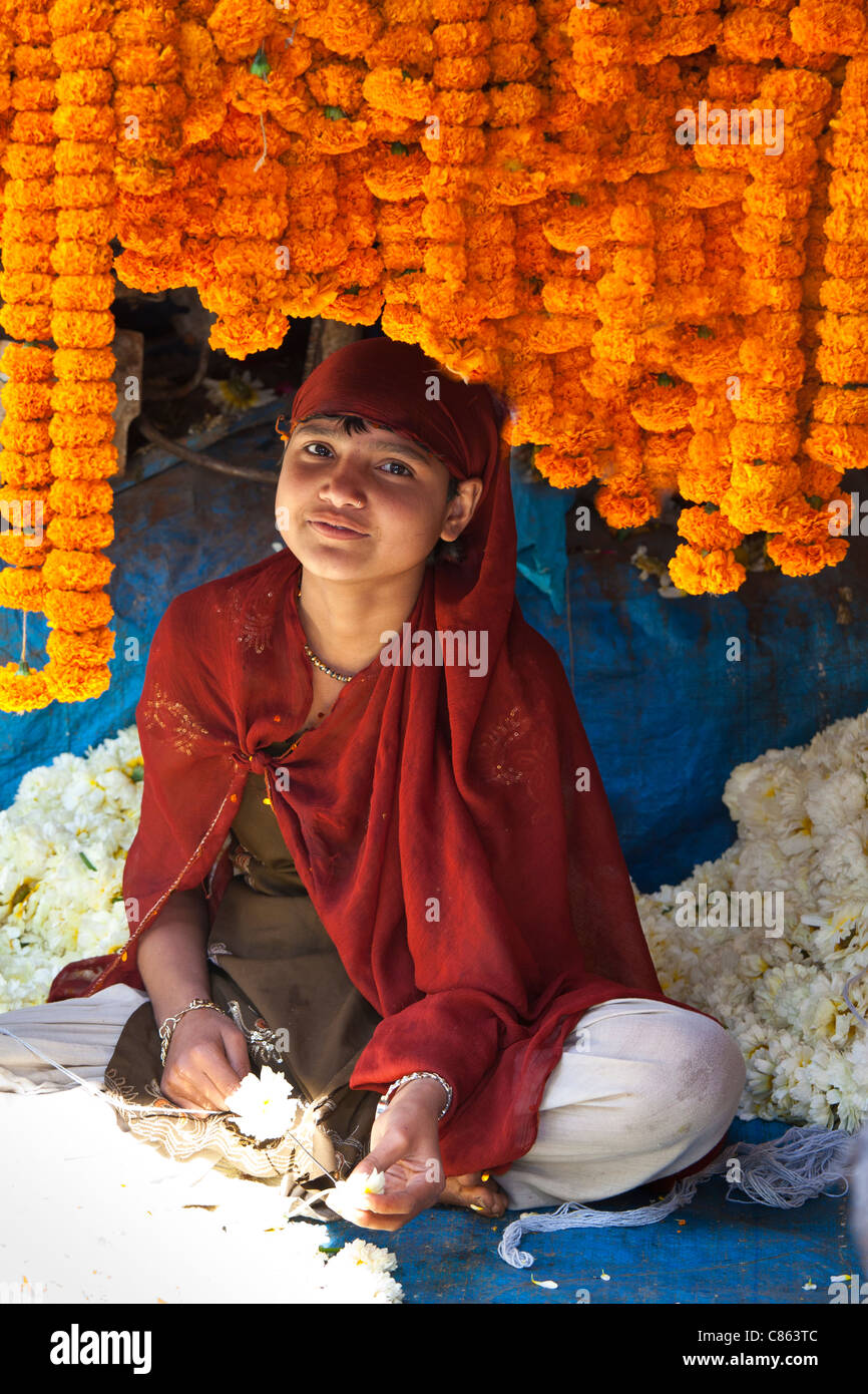 Stringing flowers into a garland hires stock photography and images