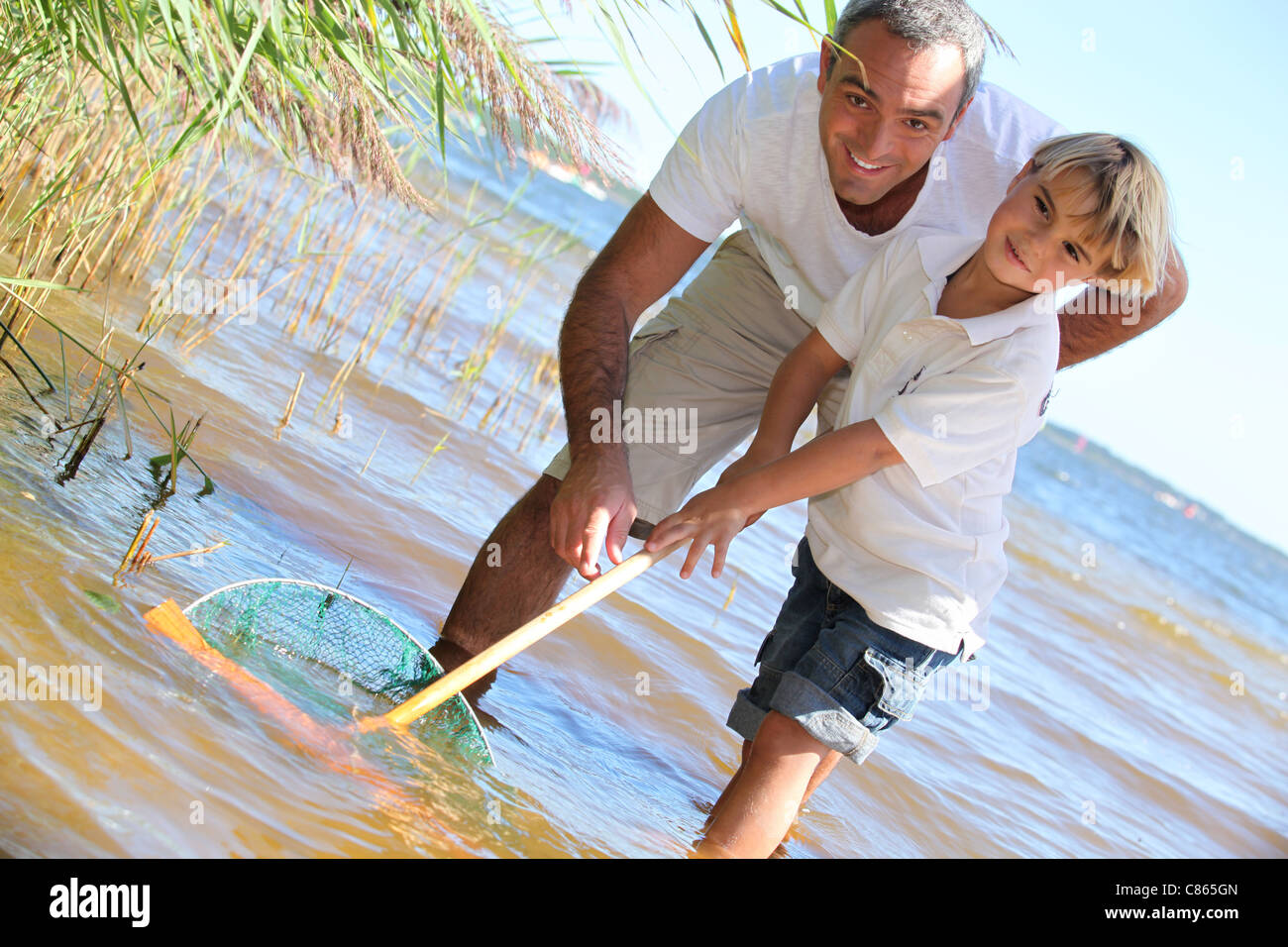 Boy holding fishing net fish hi-res stock photography and images