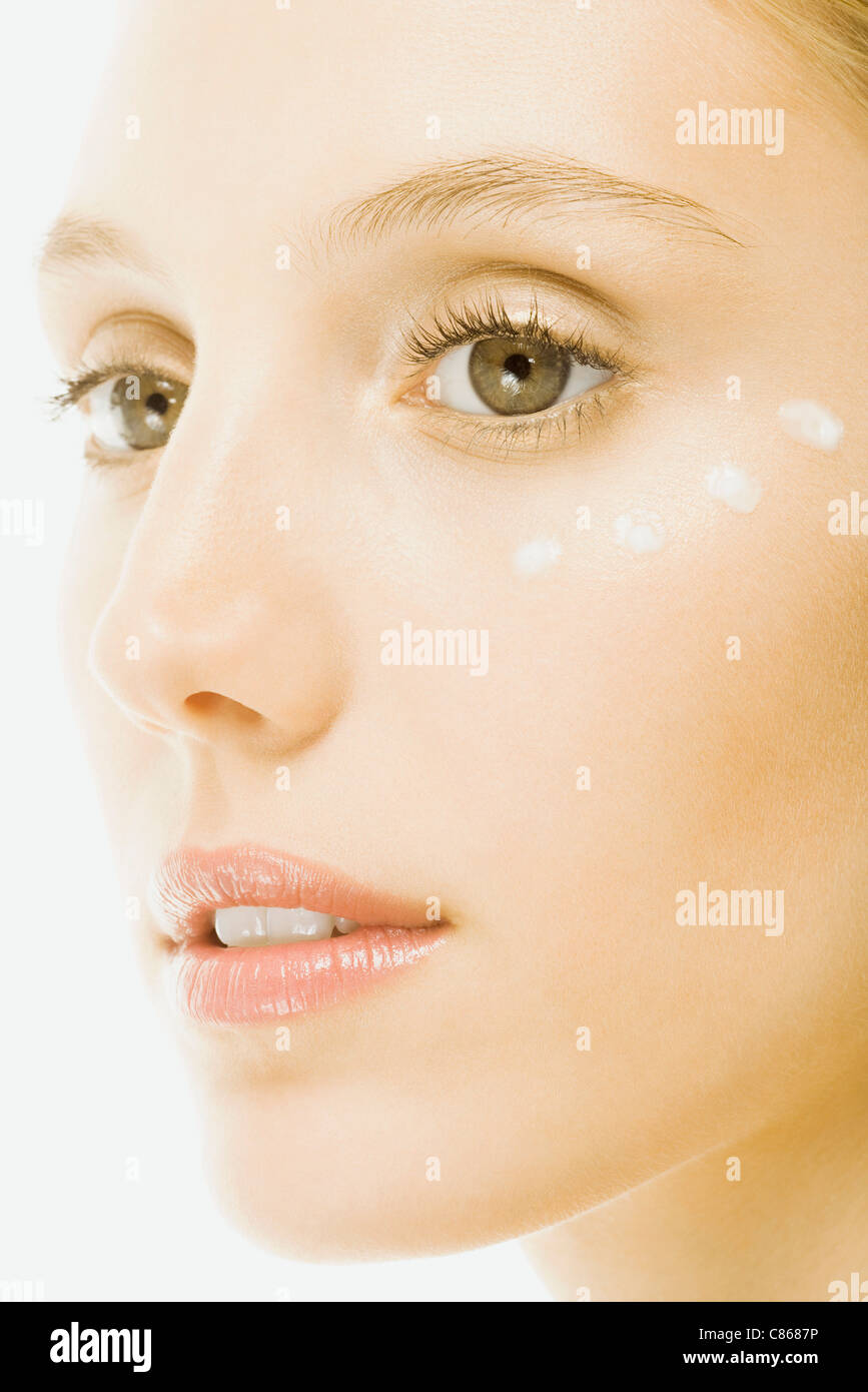 Woman with dots of undereye cream applied beneath eye, close-up of face Stock Photo