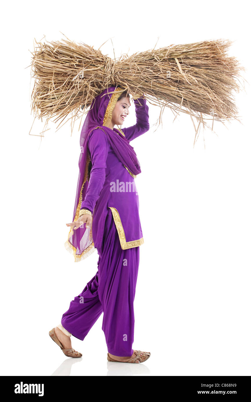 Sikh woman carrying bales of hay Stock Photo