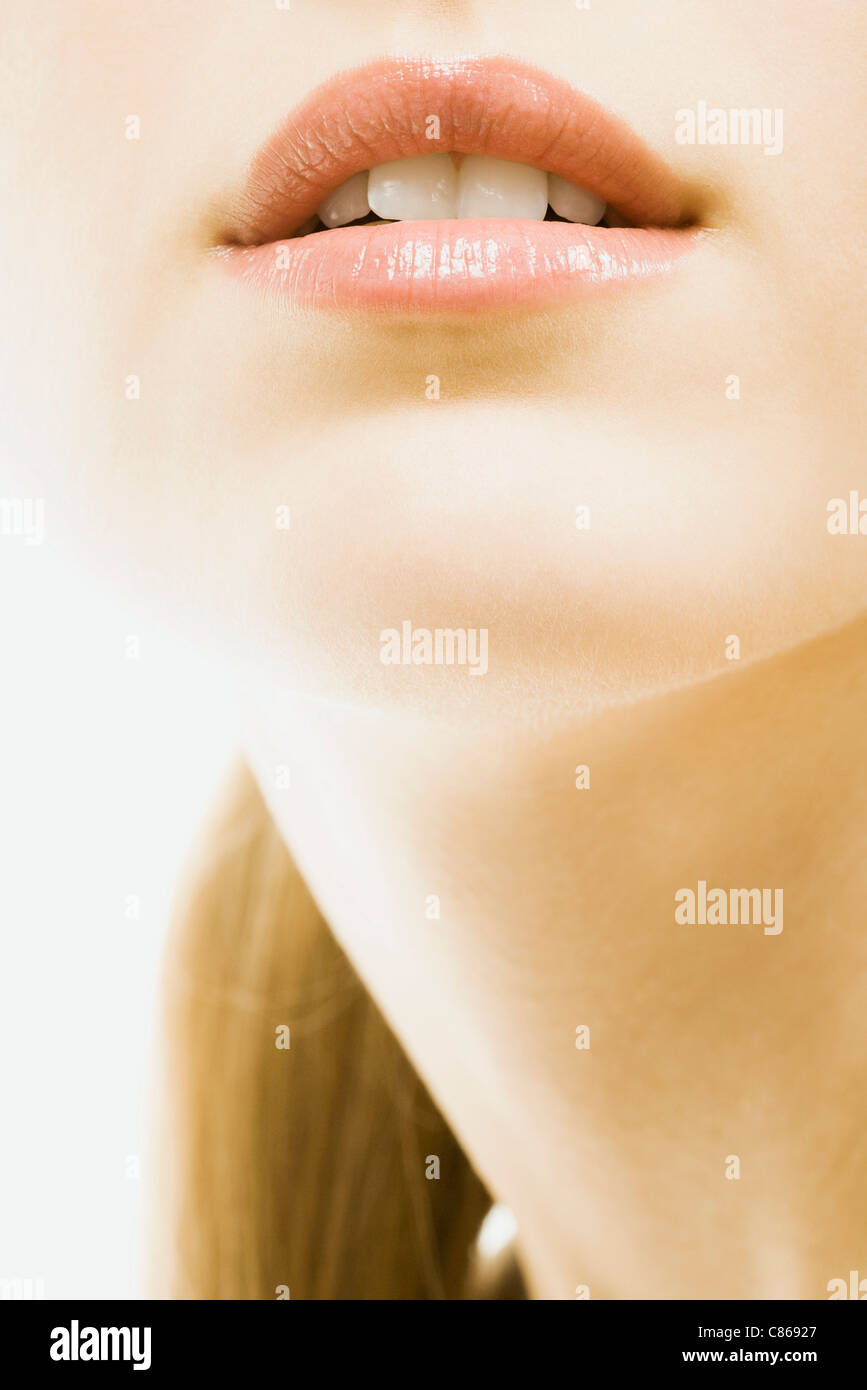 Young woman wearing lip gloss, close-up of face, cropped Stock Photo