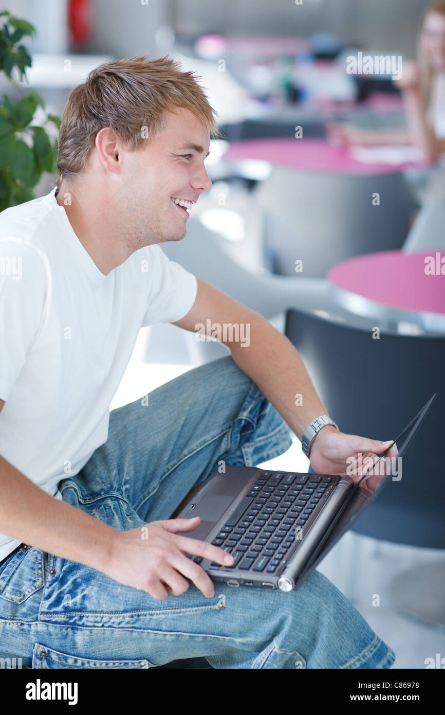 handsome college student with laptop computer in university library ...