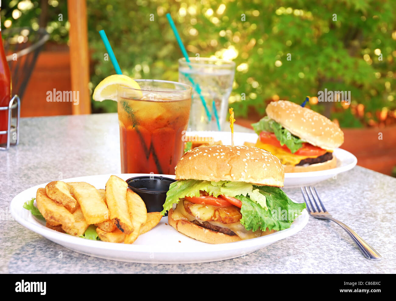 Two burgers on table at outdoor restaurant Stock Photo