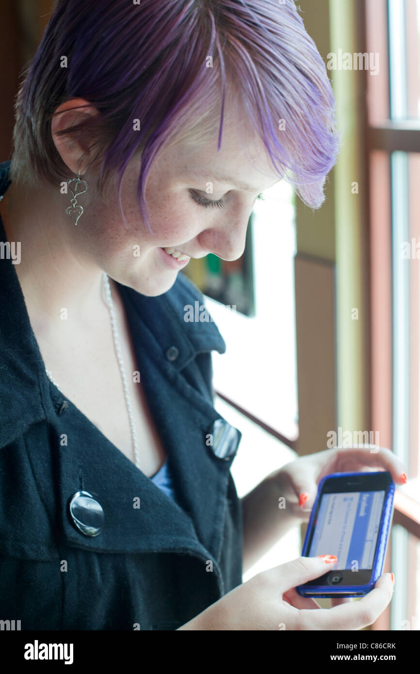 teen girl using smart phone to use facebook Stock Photo