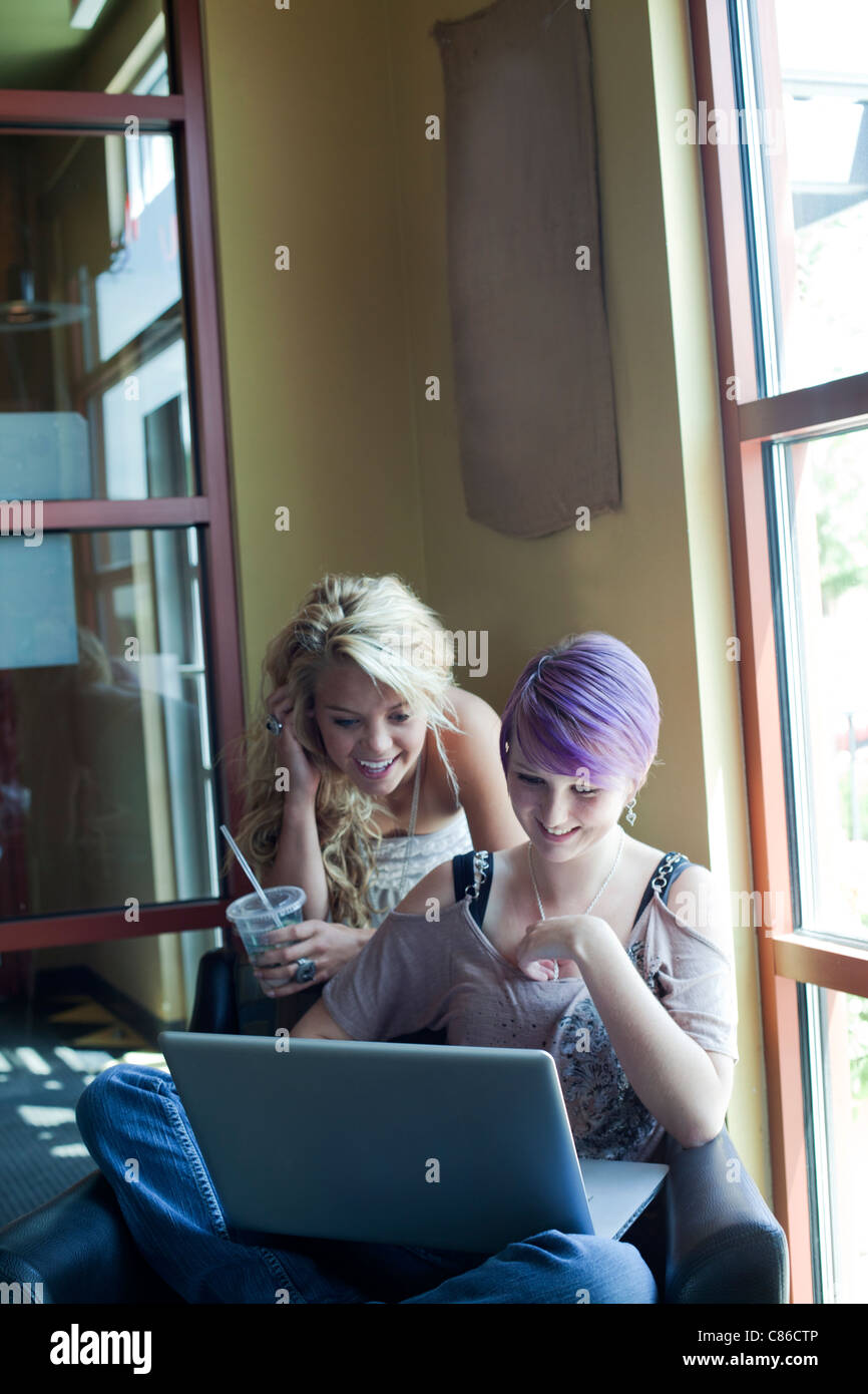 teens girls in coffee bar using laptop to surf the web Stock Photo