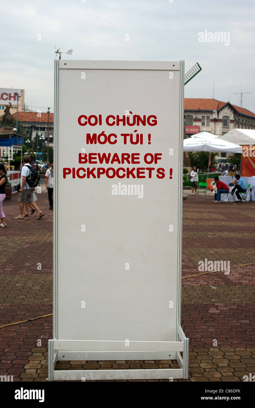 Outdoor pick pocket warning board near Ben Thanh Market, Saigon, Vietnam. Tourists in the background Stock Photo