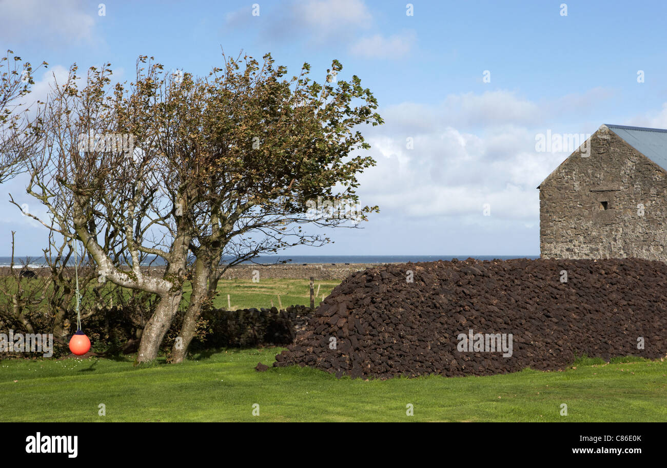 pile stacks stacked irish turf peat fuel store in a garden in the west of ireland Stock Photo