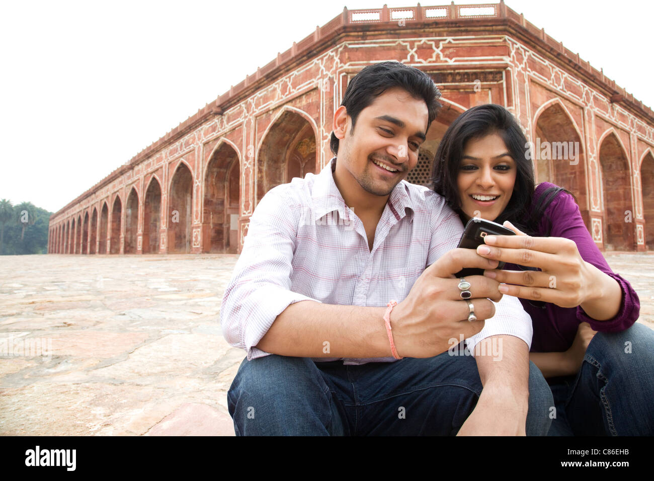 Couple reading an sms at Humayuns Tomb Stock Photo
