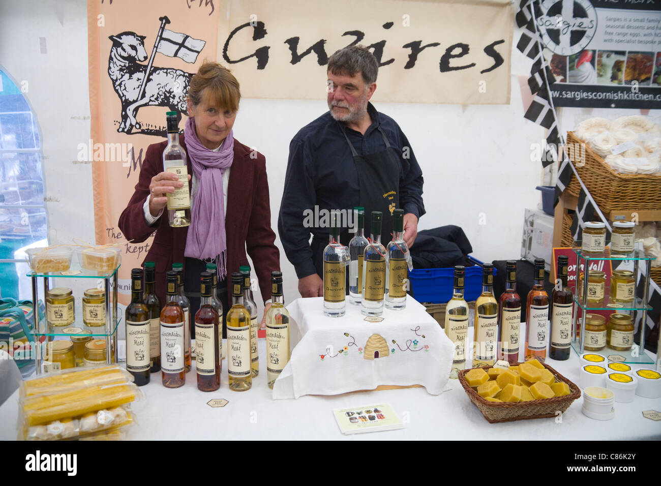 England Female Market stallholder holding bottle locally produced fruit
