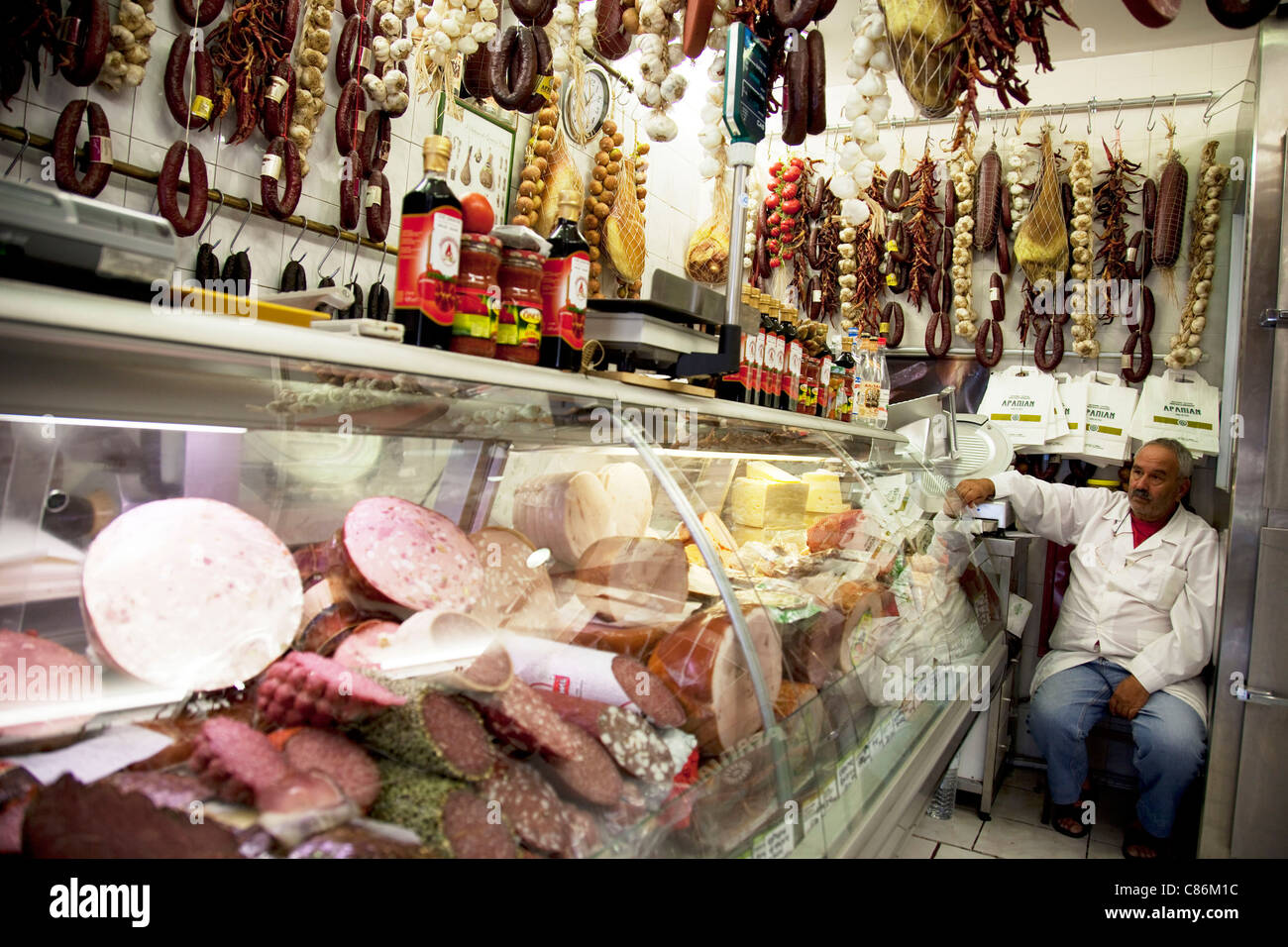 Delicatessen selling cured meats and salami in Psiri. Athens is the capital and largest city of Greece. It dominates the Attica periphery and is one of the world's oldest cities, as its recorded history spans around 3,400 years. Classical Athens was a powerful city-state. A centre for the arts, learning and philosophy. Stock Photo