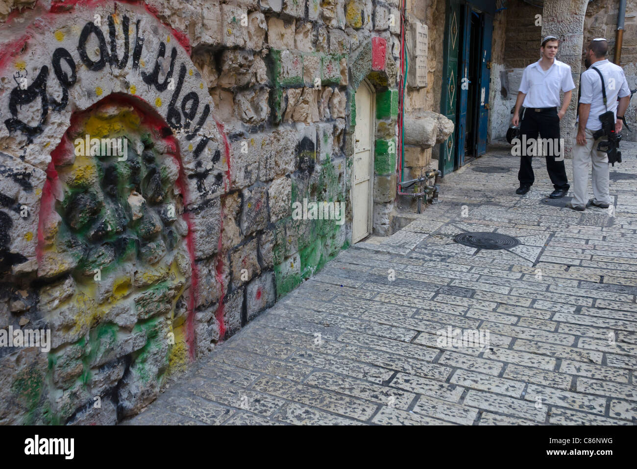 two young jewish men with gun in the streets of the Muslim Quarter. jerusalem Old City. Israel Stock Photo