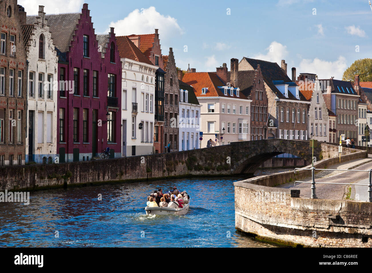 Tourist boat on the canal along the Spinolarei and Spiegelrei in Bruges,(Brugge), Belgium Stock Photo