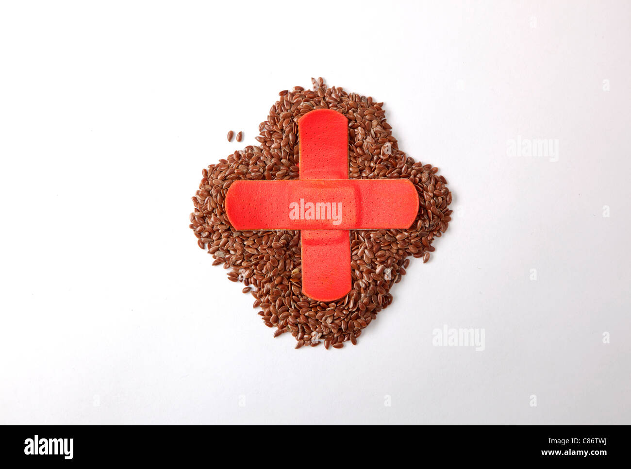 flax seeds with red cross made of bandaid over the top Stock Photo
