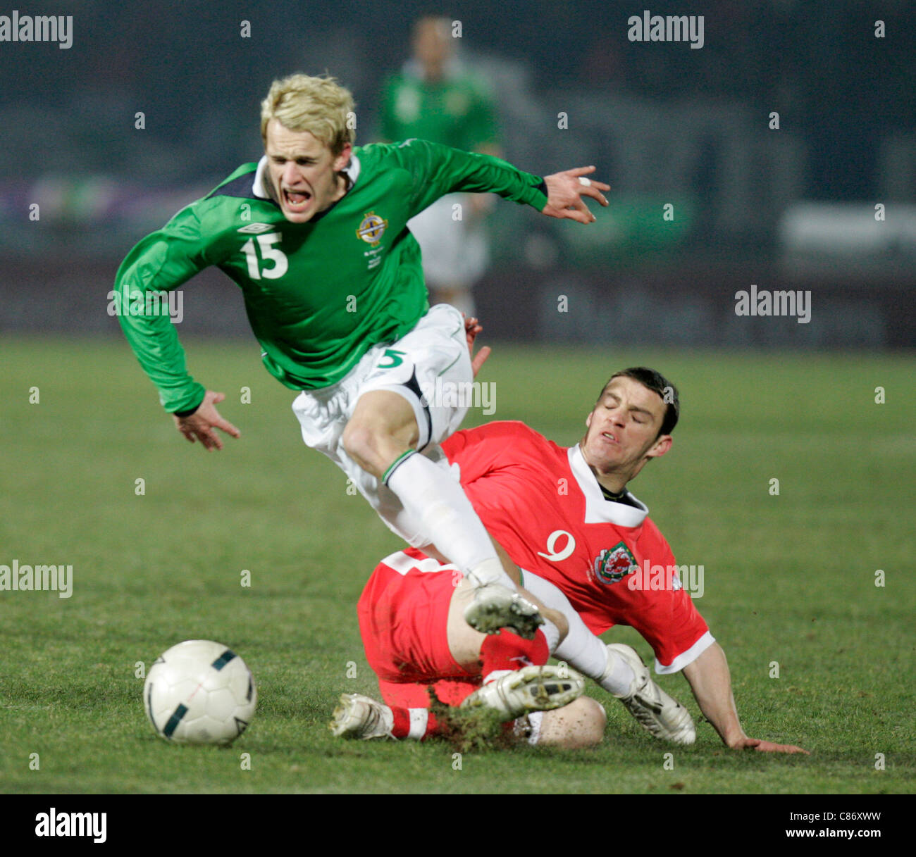 Northern Irelands Dean Shiels (15) goes flying after a tackle from behind by Wales Jason Koumas (9). Northern Ireland and Wales drew 0-0 in this friendly. Northern Ireland v Wales international friendly, Windsor Park, Belfast, 6th February 2007 Stock Photo