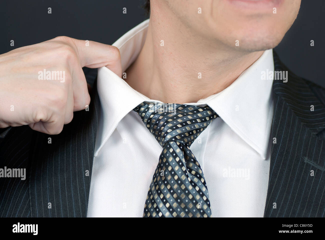 Close-up of a stressed businessman pulling at his collar. Stock Photo