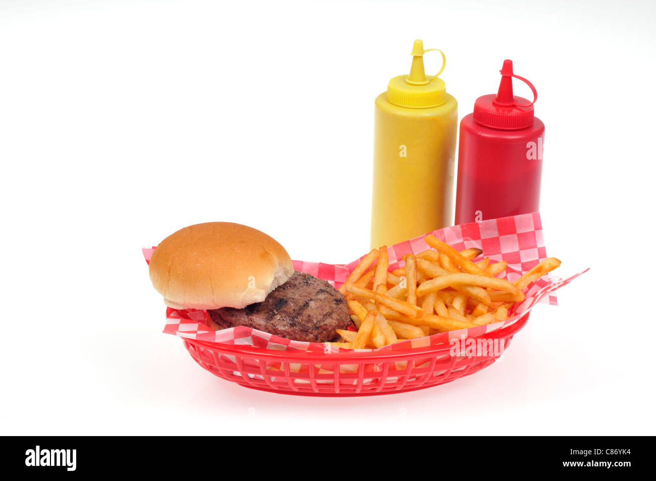 Hamburger with french fries in a red plastic retro basket with mustard and ketchup condiments on white background, cutout. USA Stock Photo