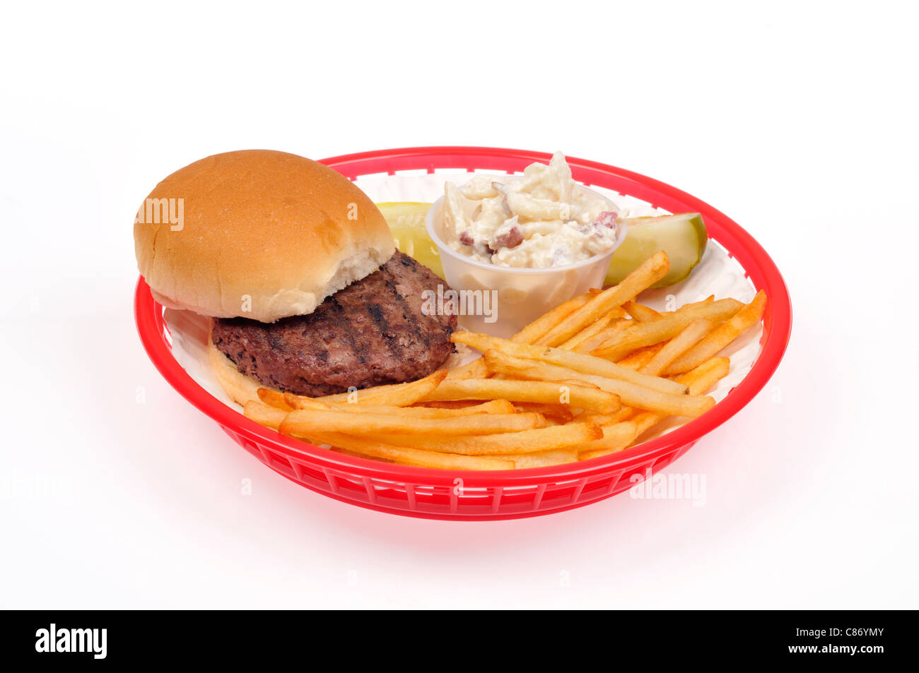 Hot grilled beef hamburger with french fries, potato salad and pickle in red plastic takeaway basket on white background, cutout. USA Stock Photo