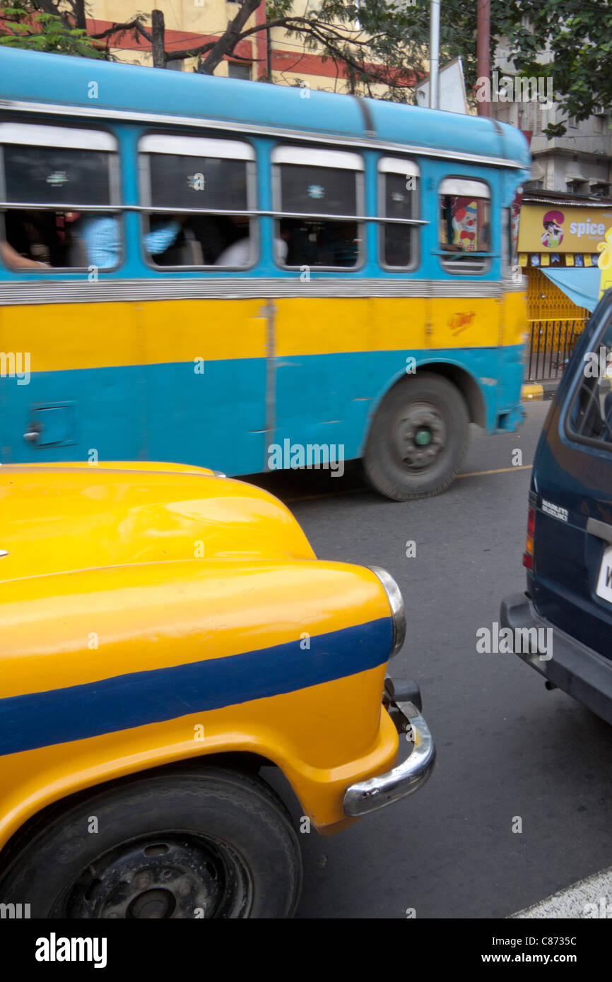 Yellow taxi and blue public transport bus in Kolkata (Calcutta), West Bengal, India. Stock Photo