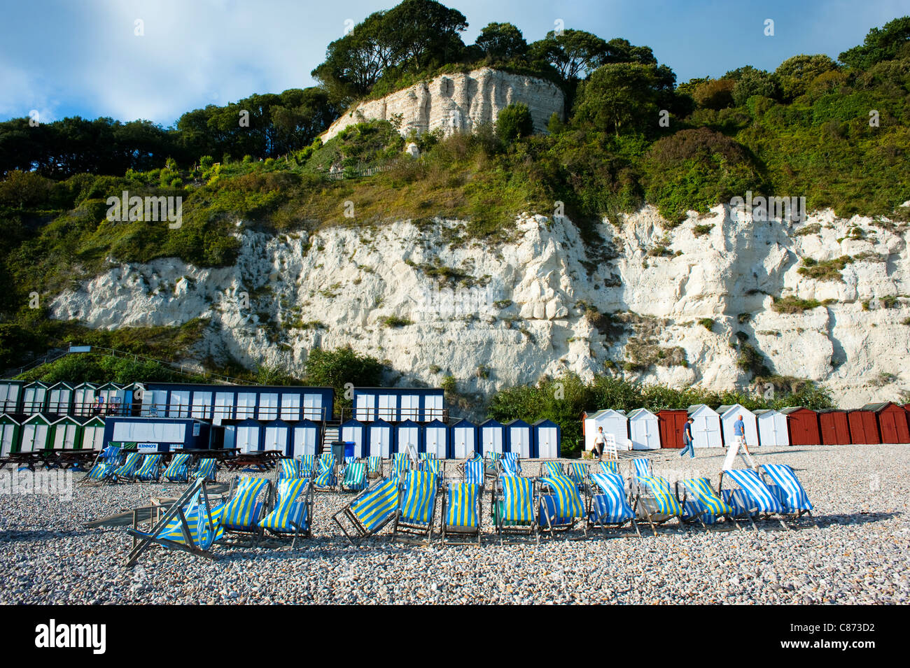 Deck chairs and beach huts at Beer, Devon, England Stock Photo