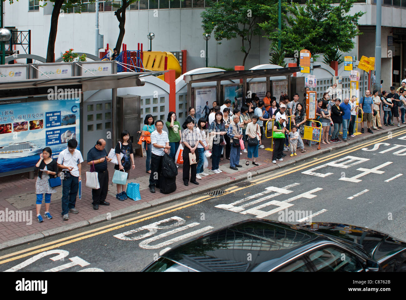 People waiting at bus stops, Wan Chai, Hong Kong Stock Photo
