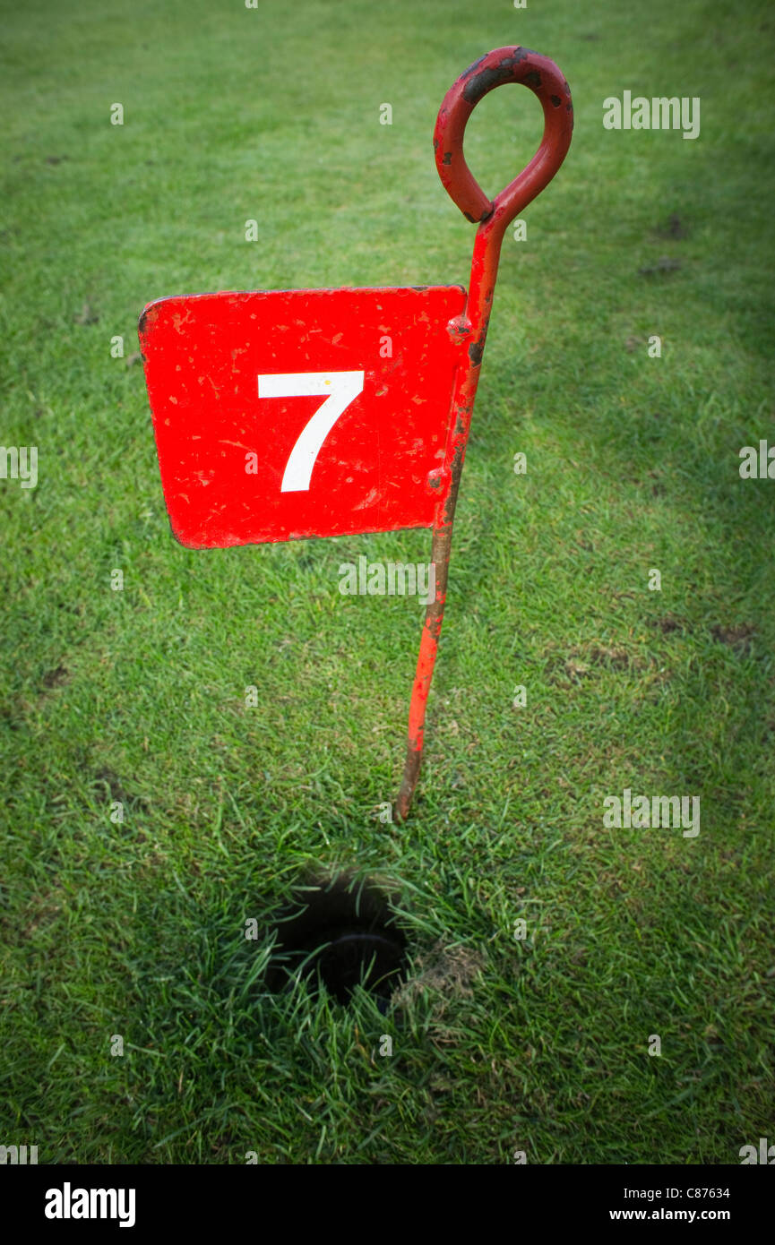 Metal no 7 hole marker on a small golf pitch Stock Photo