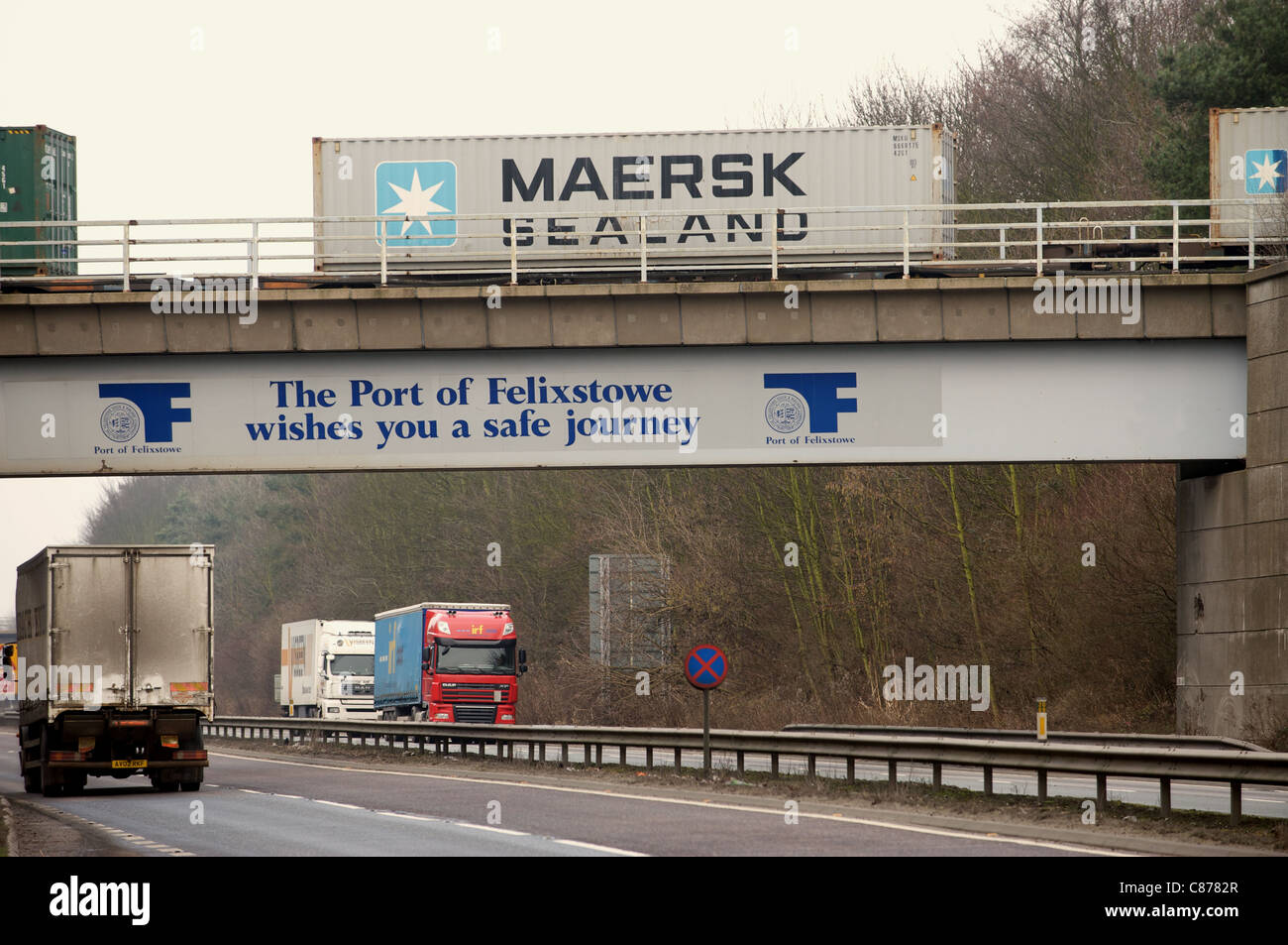 Cargo train crossing the A14 truck road, port of Felixstowe, Suffolk, UK. Stock Photo