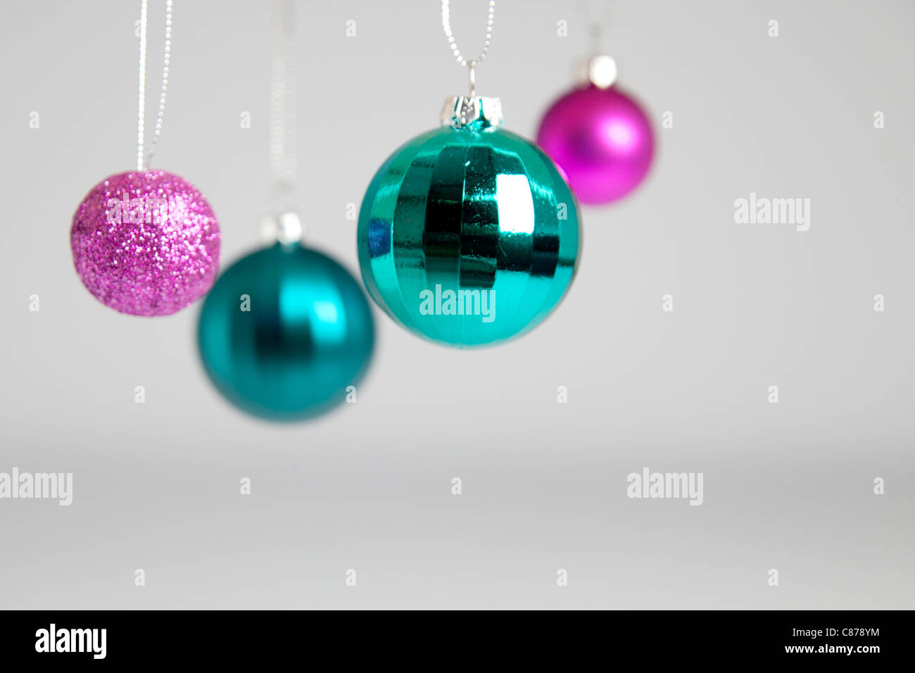 Four Christmas baubles, against a grey background Stock Photo - Alamy